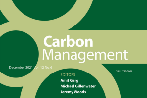 The cover of the Carbon Management Journal cropped. It's dark green with light green lines and circles. The cover reads, "Carbon Management. December 2021 Vol. 12 No. 6. ISSN: 1758-3004." The editors listed include Amit Garg, Michael Gillenwater, and Jeremy Woods.