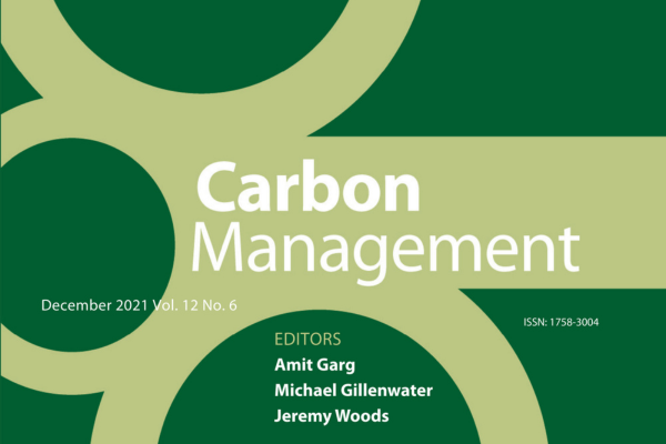 The cover of the Carbon Management Journal cropped. It's dark green with light green lines and circles. The cover reads, "Carbon Management. December 2021 Vol. 12 No. 6. ISSN: 1758-3004." The editors listed include Amit Garg, Michael Gillenwater, and Jeremy Woods.